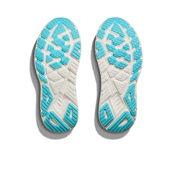Two white sneaker soles with a textured pattern and gold accents, displayed side by side, highlight the stability and support of the HOKA Womens Arahi 7 (Medium Width) White/Gold featuring J-Frame™ technology.