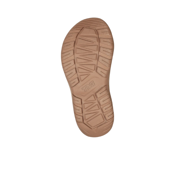 Tan rubber sole of the Teva Womens Hurricane XLT2 Ampsole Sesame sandal, featuring deep angled grooves, a textured tread pattern with the Teva logo embossed at the center. Made with recycled materials and shown against a white background.