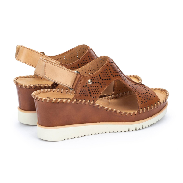 PIKOLINOS Womens Aguadulce Brandy sandals feature brown leather, white soles, decorative stitching, and laser-cut patterns. These comfy wedges have open toes, slingback straps, and platform heels designed for foot pain relief.