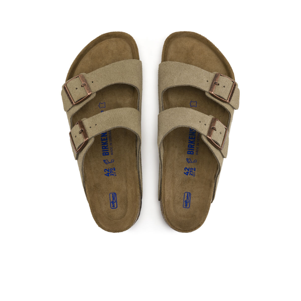 A pair of Birkenstock Women's Arizona Soft Footbed Taupe Suede sandals with two adjustable straps and buckles, side by side on a white background. The brown soft footbed features blue BIRKENSTOCK branding.