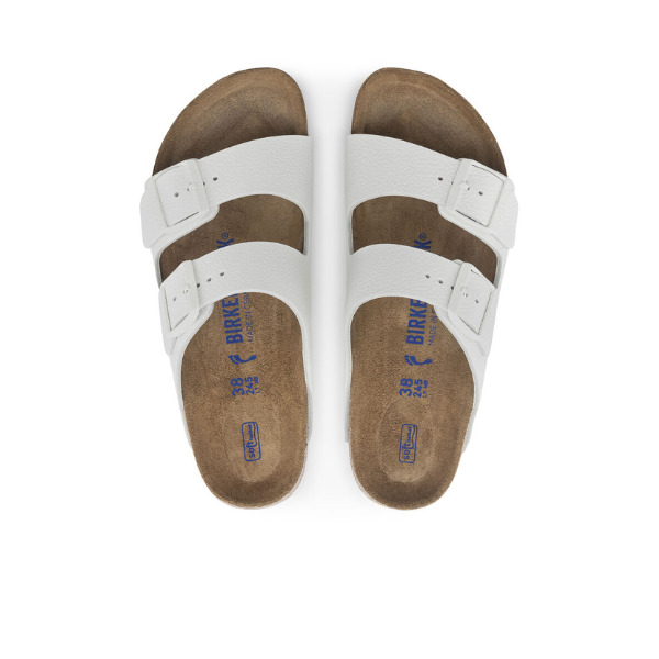 A pair of BIRKENSTOCK Womens Arizona Soft Footbed White sandals with two adjustable straps and blue branding on the insoles, shown from above on a white background.