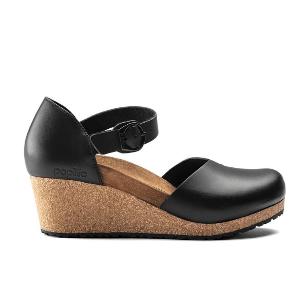 The Birkenstock Womens Mary Leather Black features a wedge heel, cork sole, closed toe, and ankle strap with buckle from BIRKENSTOCK, blending comfort and style for foot pain relief. The brand name appears on the heel area.
