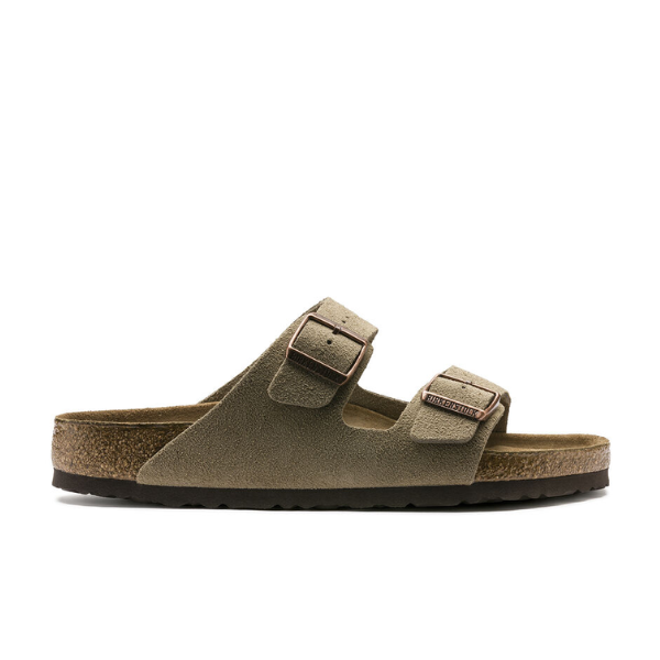 The BIRKENSTOCK Arizona Soft Footbed Taupe Suede sandal features two adjustable buckle straps, a cork soft footbed for support, suede upper, and dark rubber sole, shown in side profile against a white background.