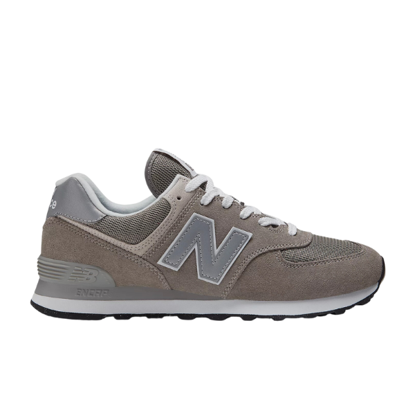The NEW BALANCE Mens 574 Core Neutral features a gray suede and mesh upper, white laces and sole, plus a bold silver “N” logo—versatile footwear ideal for any men’s shoe collection.