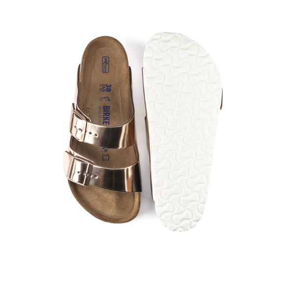 A pair of BIRKENSTOCK Womens Arizona Soft Footbed Leather Sandals in White Copper; one sandal is shown from the top, highlighting two buckled straps, while the other displays the textured white sole.