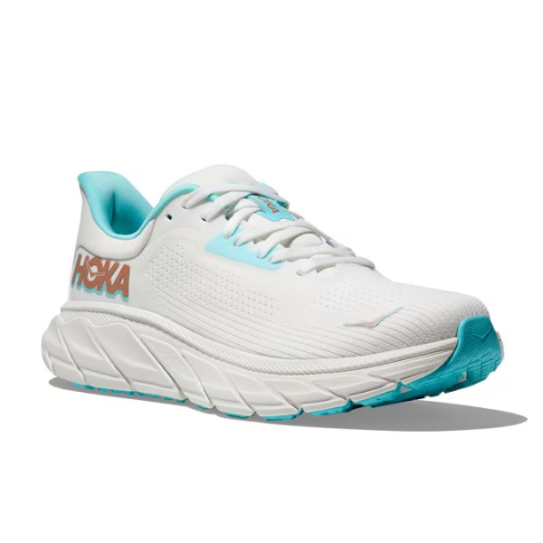 The HOKA Womens Arahi 7 (Medium Width) in White/Gold features a thick, cushioned sole, supportive J-Frame™ technology, gold brand accents, and a comfortable lining for stylish running performance.