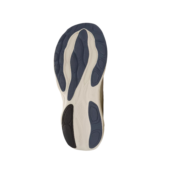 The image shows the sole of the New Balance Mens Fresh Foam X 1080v14 Wide Sea Salt, featuring a beige base with blue and black rubber grip patterns against a white background. This NEW BALANCE model highlights Fresh Foam X comfort technology.