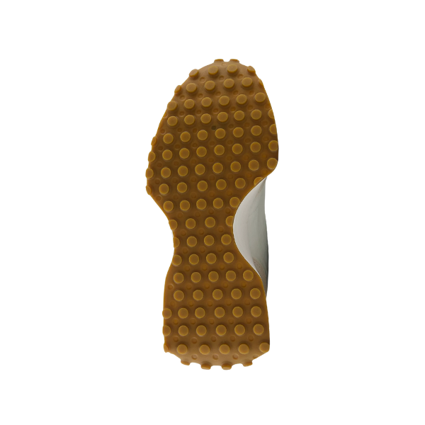 The image shows the sole of the NEW BALANCE Womens 327 White/Olive, a retro-style running shoe with a brown rubber outsole featuring round grip patterns and an arch curve, combining vintage appeal and comfort against a white background.