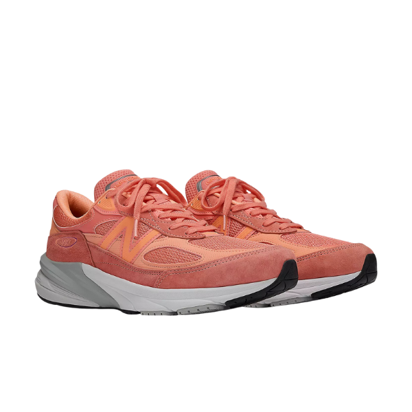 A pair of New Balance Womens 990v6 Rose sneakers by NEW BALANCE, featuring coral pink mesh and suede uppers, large N logos, FuelCell midsole cushioning, and white-gray cushioned soles. Both MADE in USA shoes are side by side, facing right.