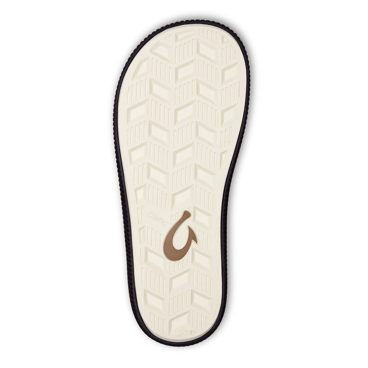 The image displays the sole of the OLUKAI Mens Ulele Black sandal, featuring a water-resistant herringbone cream tread with a black edge and brown hook logo by the heel, designed for comfortable support.