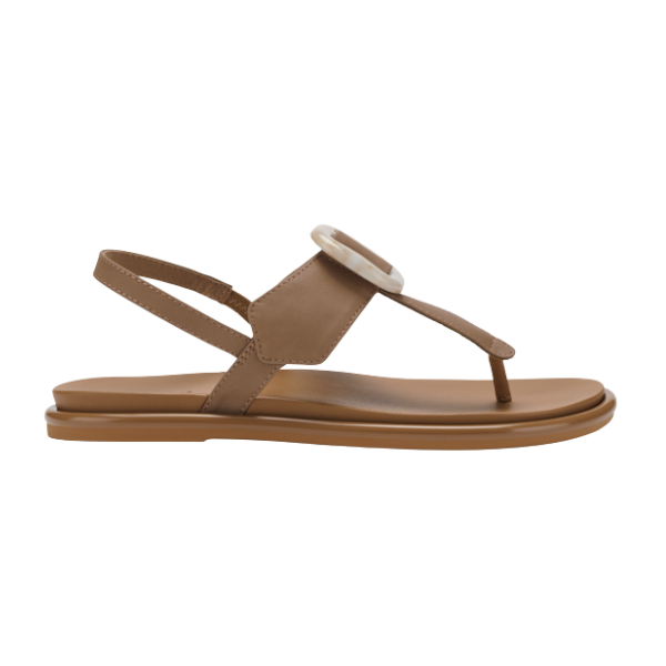 The OLUKAI Womens La‘i T–Bar Tan sandal features a flat sole, thong strap, Wide instep band with a circular buckle, open heel, and ankle strap—combining fashion-forward style with comfort.