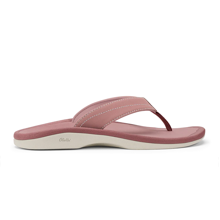 The OLUKAI Womens Ohana Coral Rose is a thong-style flip-flop sandal with an anatomical footbed, white stitching, and a white sole, shown in a side profile view.