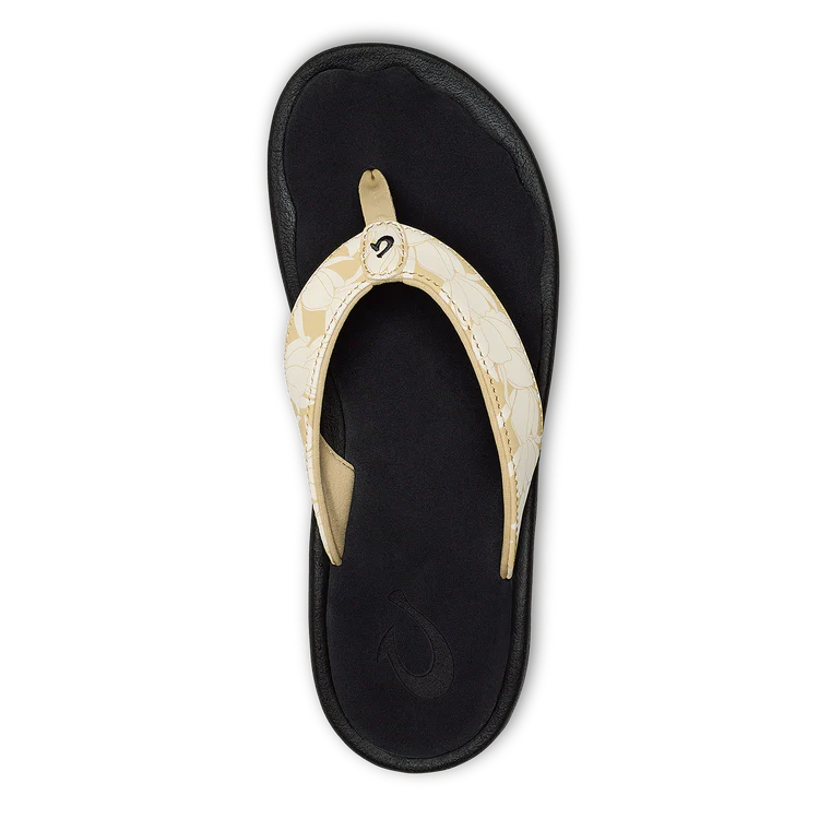 An OLUKAI Womens Ohana Toasted Coconut sandal with a patterned strap and dark, water-resistant anatomical footbed is shown from above on a plain white background.