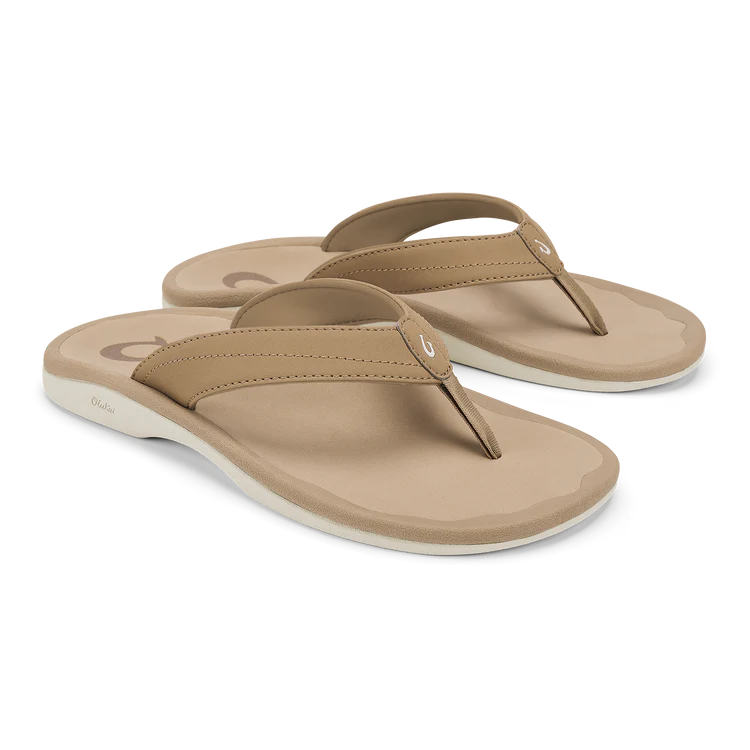 A pair of Olukai Womens Ohana Warm Sand sandals by OLUKAI, featuring thick cushioned water-resistant soles and a subtle logo on the strap, displayed against a white background.
