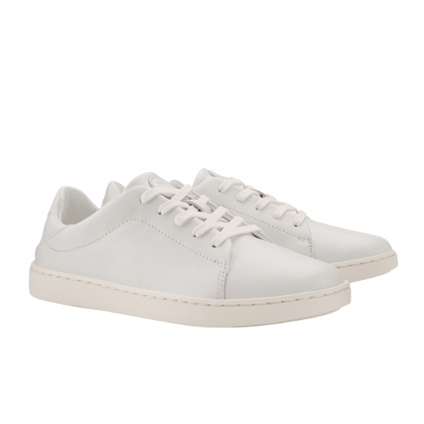 The OLUKAI Womens Pehuea Lī ‘Ili Leather White sneakers are low-top, white leather shoes with white laces and off-white rubber soles, designed for comfort and foot pain relief, shown against a plain white background.
