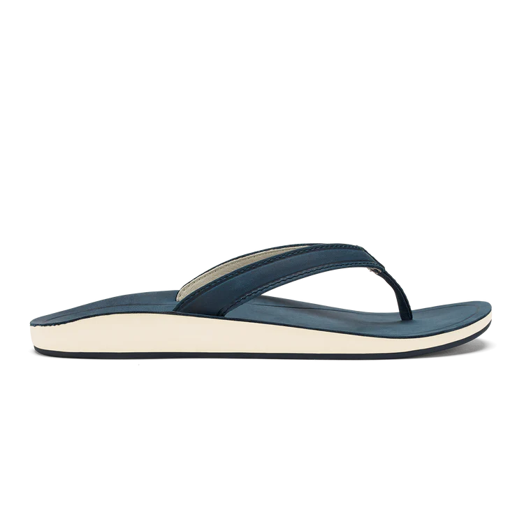 A side view of the OLUKAI Women’s Southshore Indigo sandal, featuring a blue thong strap design and a white comfort sole.