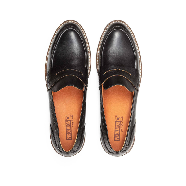 The PIKOLINOS Womens Aldaya Black loafers feature brown cushioned insoles, white stitching around the soles, and the Pikolinos logo, shown from above on a white background.