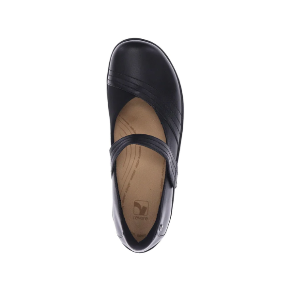 Top view of the Revere Womens Timaru Mary Jane Black by REVERE—a black orthotic Mary Jane shoe with a strap and tan cushioned insole, designed for comfort and ideal for plantar fasciitis, shown on a white background.