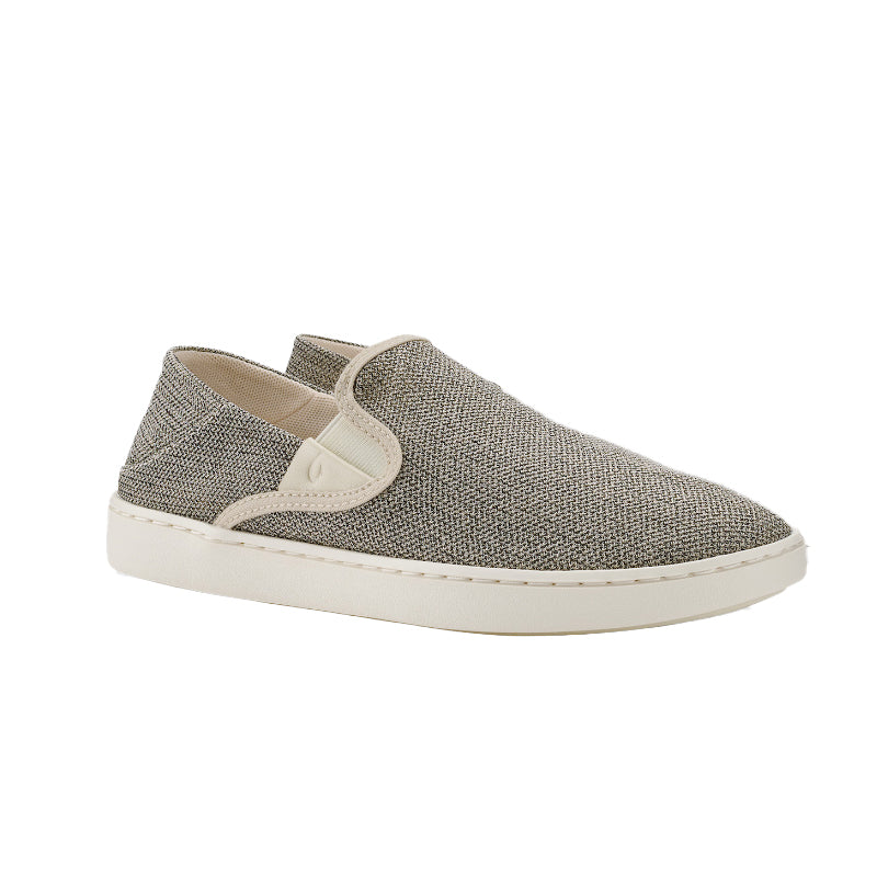 The OluKai Womens Tape Pehuea by OLUKAI is a slip-on shoe featuring a textured gray upper, anatomical footbed, white elastic side details, and a white rubber sole, inspired by the Pehuea design and shown on a plain white background.