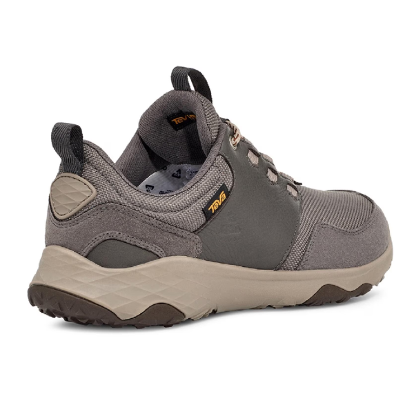 The Teva Mens Canyonview RP Grey/Burro is a gray athletic hiking shoe with a beige sole, textured heel, dark gray accents, and Teva branding on the ankle and inner lining for added foot pain relief, viewed from the back and side.