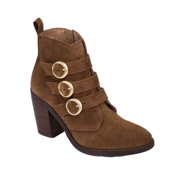The NASSIMA Nassima Womens Tours 005 Brown Suede bootie features a chunky high heel, three gold-buckled side straps, pointed toe, back pull tab, and subtle arch support for comfort all day.