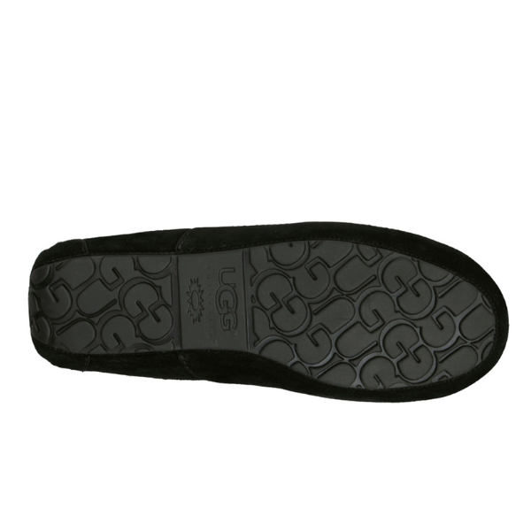 The image displays the sole of the UGG Mens Ascot Slipper Black by UGG, highlighting a textured pattern with the UGG logo and sun symbol, designed to provide comfort for foot pain.