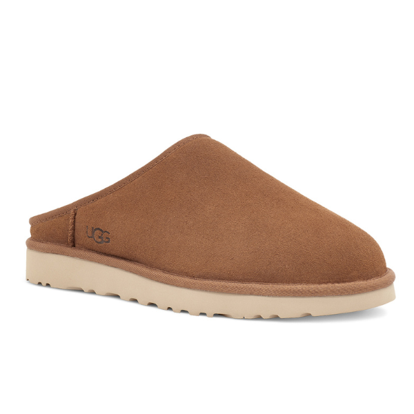 The UGG Mens Classic Slip-On Chestnut is a tan suede sheepskin slip-on slipper with a closed toe, open back, and light beige rubber sole, featured on a white background.