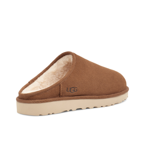 The UGG Mens Classic Slip-On Chestnut features brown suede, a cream shearling lining, beige rubber sole, and UGG logo. This mens slip-on has a closed toe, open back, and is crafted for comfort and foot pain relief.