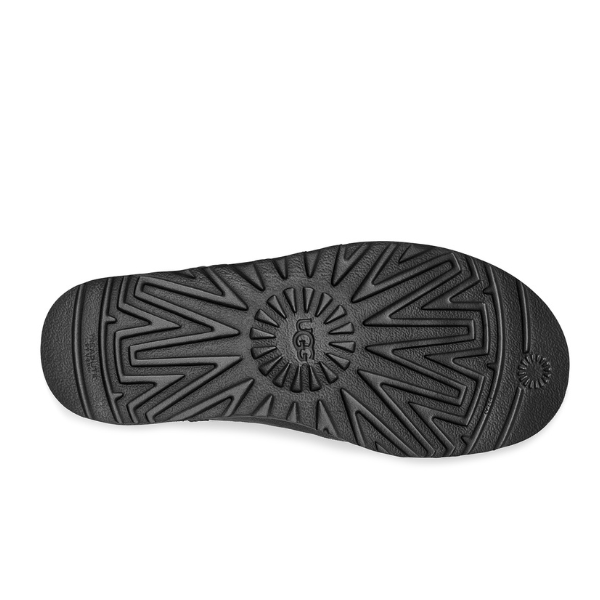The UGG Womens Classic Short II Boot in Black features a black sole with zigzag and circular tread, UGG logo at the center, and is designed for comfort—ideal for relieving foot pain.