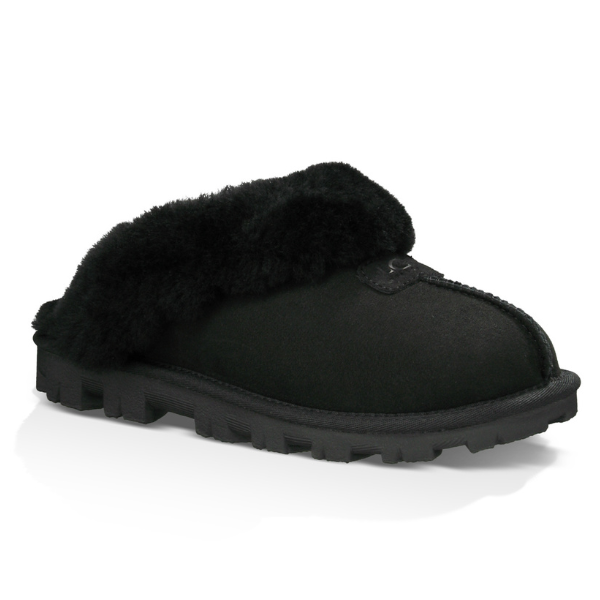 The UGG Womens Coquette Slipper Black features a plush furry collar, soft sheepskin, and a rugged textured sole for warmth, comfort, and foot pain relief.