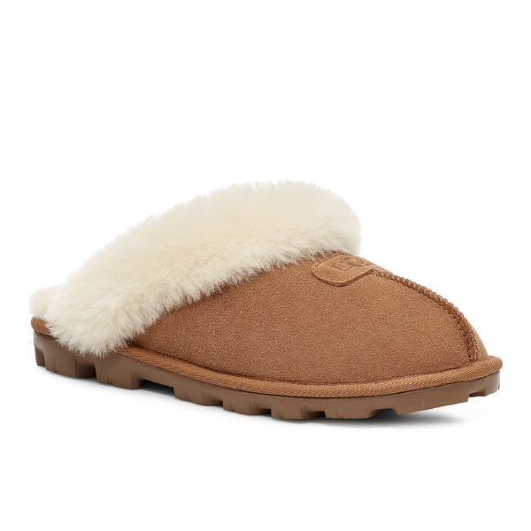 The UGG Womens Coquette Slipper Chestnut features a tan suede upper, rubber sole, and plush white sheepskin fleece lining, shown angled on a white background.