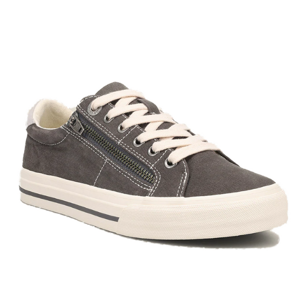 The TAOS Womens Z Soul in Graphite/Light Grey Distressed is a gray suede low-top sneaker with white laces, black-striped white sole, side zipper, and removable footbed. Shown angled to display the side and front.