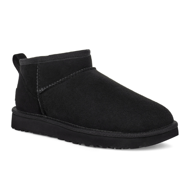 The UGG Womens Classic Ultra Mini Boot Black features black suede, a round toe, visible stitching, heel pull tab, flat textured rubber sole, and cozy sheepskin lining.