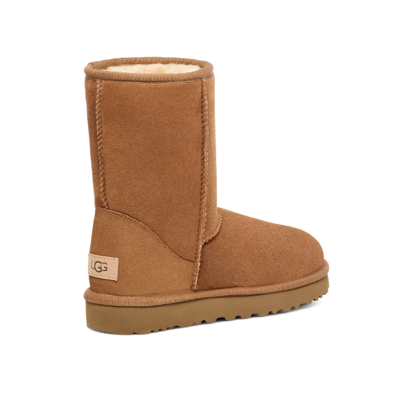 A single UGG Womens Classic Short II Boot in Chestnut, featuring tan suede, a sheepskin lining, and a flat rubber sole, is shown from the side and slightly behind with the UGG logo tag near the heel.
