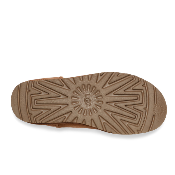 The image shows the bottom view of the UGG Womens Classic Short II Boot in Chestnut, featuring a textured zigzag and sunburst tread with UGG embossed in the center, showcasing its sheepskin craftsmanship.