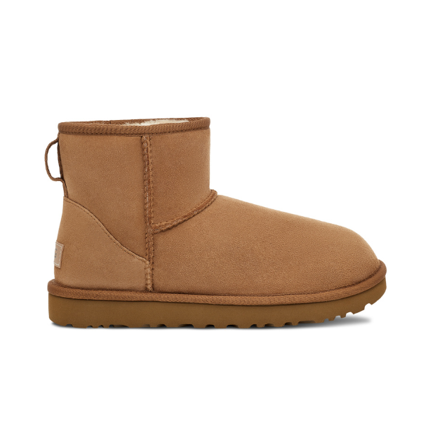 A single UGG Womens Classic Mini II Boot in Chestnut, featuring tan suede, visible stitching, and a flat, textured sole, is shown side profile on a white background. Enjoy signature UGG comfort and foot pain relief with every step.