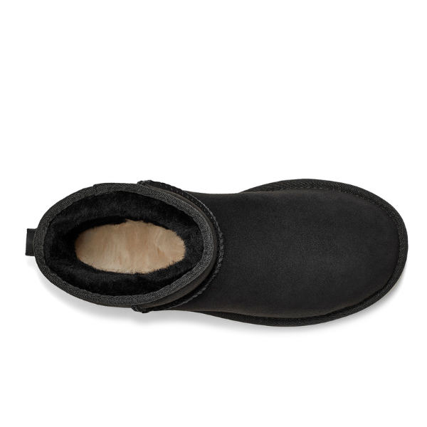 Top view of a single UGG Womens Classic Mini II Boot in black suede with a rounded toe, black outsole, and visible soft light beige fleece lining, known for cozy comfort and foot pain relief.