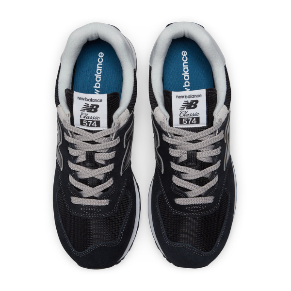 The New Balance Unisex 574 Black with White shoes feature gray laces, white tongue labels, blue insoles, and gray collar accents—designed for style and comfort to help reduce foot pain.