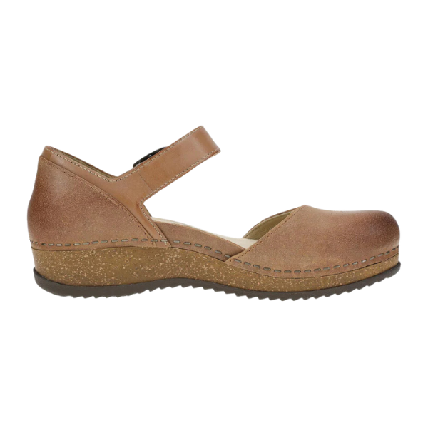 Dansko Womens Mae Tan Suede by DANSKO features a closed toe, low wedge heel, ankle strap, visible stitching, and lightweight EVA and cork soles. Shown in side profile on a white background.