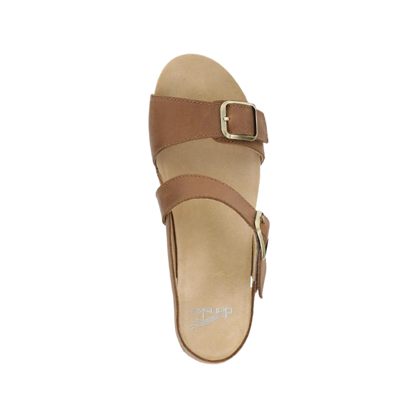 A tan open-toe sandal, Dansko Womens Trinity Tan Burnished Nubuck by DANSKO, features two straps with gold buckles, a supportive footbed for comfort, and is viewed from above on a white background.