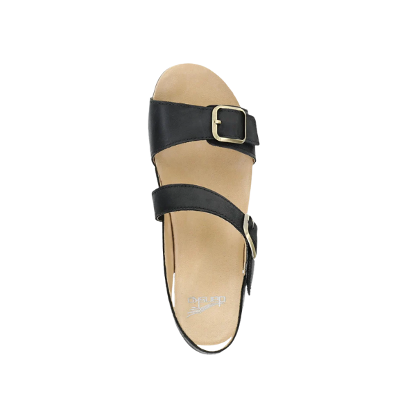 The Dansko Womens Trinity Black Burnished Nubuck sandal by DANSKO features two straps with gold buckles, a tan contoured footbed for arch support, and an open toe design, all displayed on a white background.