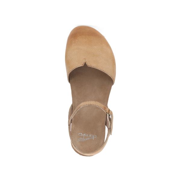 Top view of the Dansko Womens Rowan Honey Distressed sandal by DANSKO, featuring a closed toe, ankle strap with small buckle, and cork midsole, displayed on a white background.