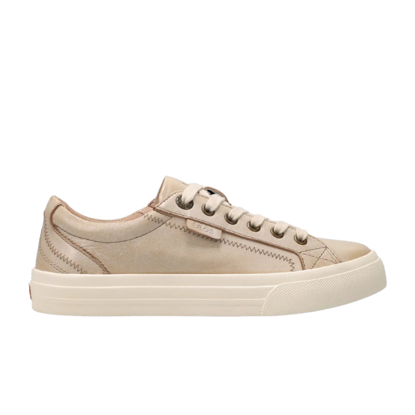 The TAOS Womens Plim Soul Lux Oyster is a beige low-top sneaker with a rubber sole, beige laces, visible stitching, and a side logo tag. Its Curves & Pods footbed offers metatarsal support for comfort in this simple, casual design.