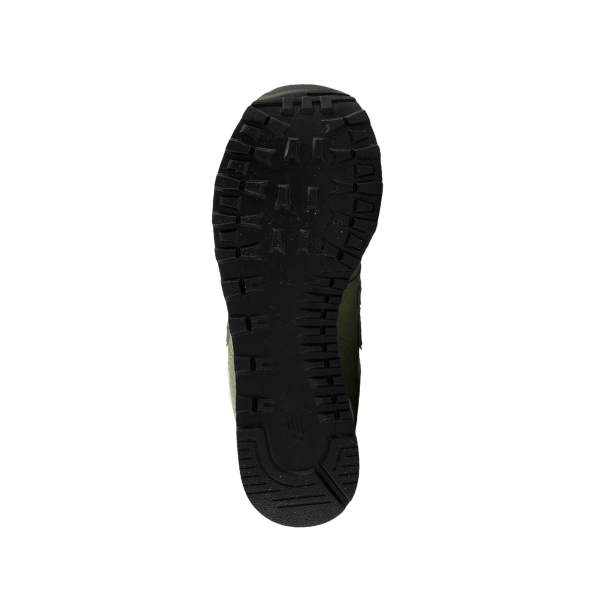 A single black rubber sole from the NEW BALANCE Unisexs 574 Green/White shoe is displayed on a white background, highlighting its textured tread pattern designed for reduced foot discomfort.