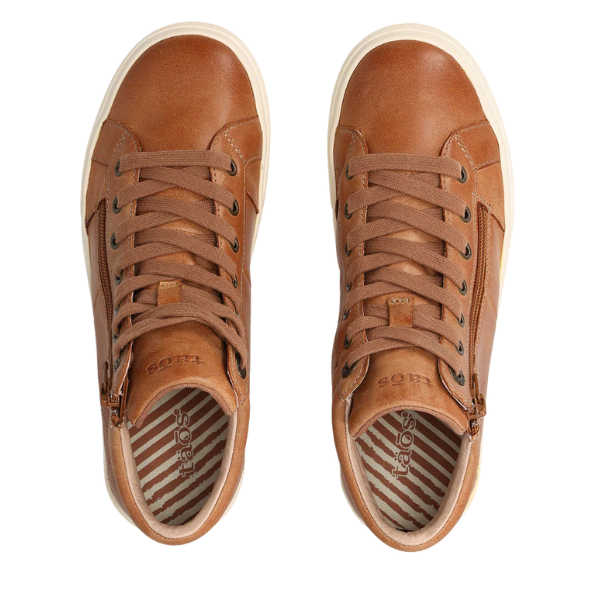 The TAOS Taos Women's Winner Caramel features brown high-top leather, tan soles, brown laces, side zippers, striped lining, and a removable footbed—shown in an overhead view.