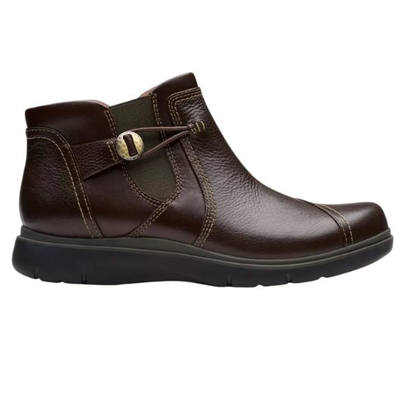 The CLARKS Certina Joy Wide Brown women's ankle boot features dark brown leather, a black rubber sole, stylish stitching, and a side buckle for comfort and support. Shown in profile on a white background.