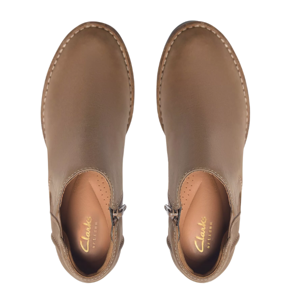 Top view of CLARKS Women's Kastela Lo Pebble Leather ankle boot in brown, with visible stitching, side zippers, and a Contour Cushion footbed, shown on a white background.