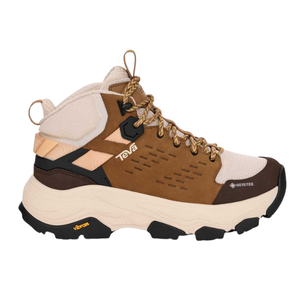 The TEVA Women's Grandview Max GORE-TEX Honey is a brown and beige waterproof hiking boot with black accents, thick sole, yellow Vibram branding, lace-up closure, Gore-Tex material, and the Teva logo on the side.