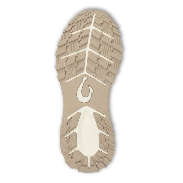 The outsole of the OLUKAI Women's Makiki Lava White Sand features beige and white textured tread for all-terrain grip, with a stylized hook logo in the center, shown from the bottom against a white background.