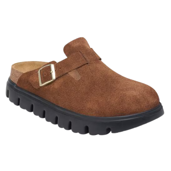 The Birkenstock Women's Boston Chunky Dark Tea is a closed-toe clog in brown suede with a gold buckle strap, soft footbed, and thick black treaded sole from BIRKENSTOCK.